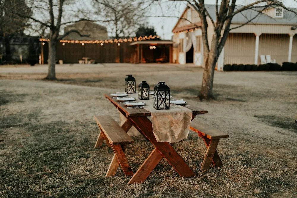 Mesa de picnic de madera con bancas en un jardín